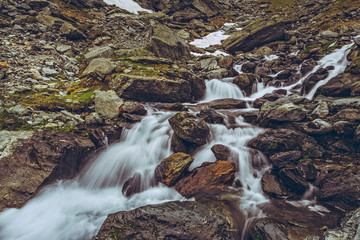 Swift mountain stream rapids flowing nearby the famous Transfagarasan road in Fagaras mountains,...
