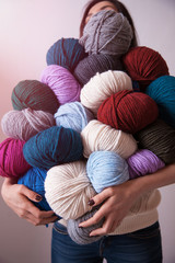 Woman holding many colorful  yarn clews