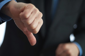 Businessman gesturing thumbs down sign