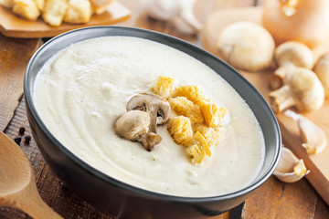 Mushroom cream soup on a brown wooden table, European food