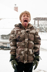 Boy sticking tongue out in Snow