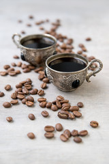 Coffee in silver vintage cups on wooden background