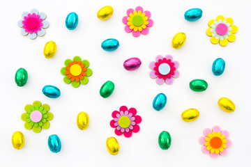 A spring time background of coloured Easter eggs and colourful flowers on an isolated, white background.