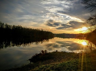 Sunset over Lake with reflection of clouds and sun
