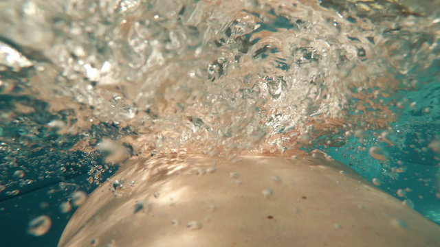BREASTSTROKE: An athlete is swimming in a swimming pool (back view - action cam)
