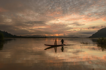 fisherman and boat at sunrise