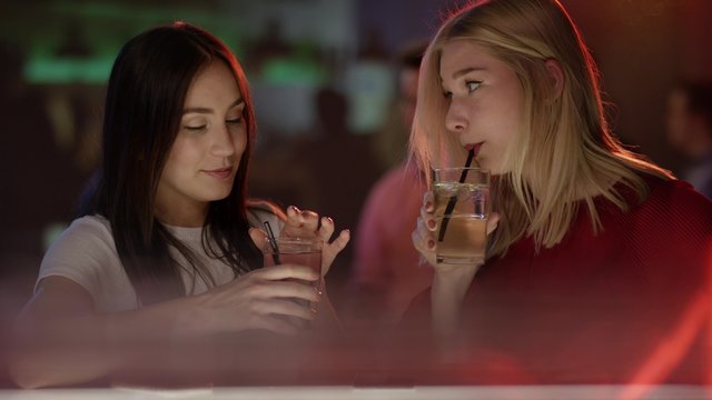 Mädchen mit Drink an Bar
