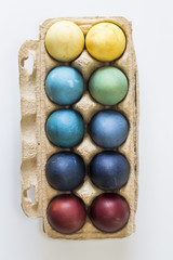 Easter, colorful painted eggs in in a cardboard box. Each color is from the different natural colorant.