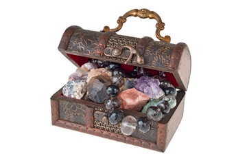Chest of minerals and beads. Treasures of the earth. Isolated on a white background. The picture was taken with limited depth of field. In the frame there are areas of blurring.
