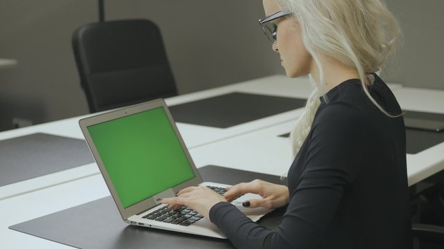 Girl Typing and Using Touchpad on Laptop with Green Screen in Office 