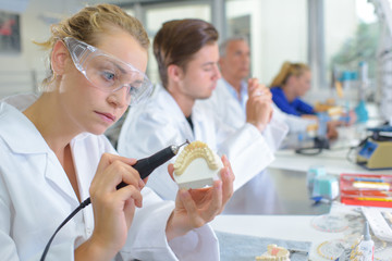 Dental technician grinding tooth