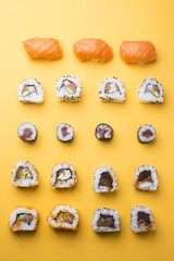 Various kinds of sushi food served on yellow blackground