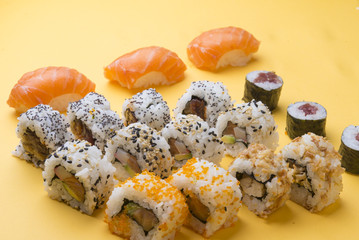 Different Sushi rolls,wasabi and ginger on a plate on wooden bac