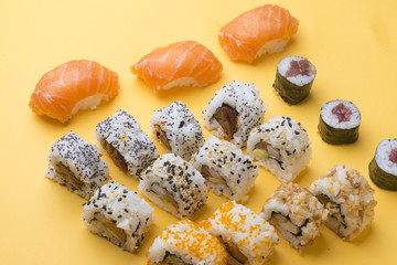 Different Sushi rolls,wasabi and ginger on a plate on wooden bac