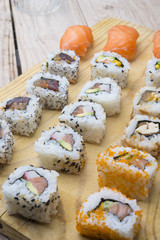 Different Sushi rolls,wasabi and ginger on a plate on wooden bac