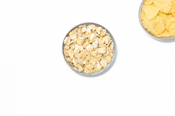 Rolled oats in a round bowl on a white background