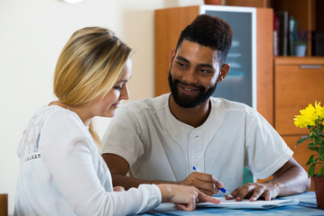 Young couple filling forms of banking application in domestic in