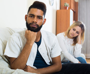 Blonde girl yelling at black boyfriend as quarreling indoors