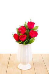 Red roses in pot on wood texture isolated on white background