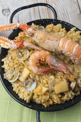 Vegetable paella with seafood on a wooden background