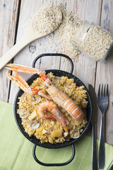 Vegetable paella with seafood on a wooden background