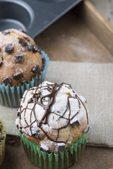 Photo of tasty cupcakes with chocolate over wooden table