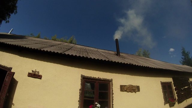 White thick smoke coming from the chimney of the forge in the mountains