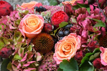 Herbstliche Blütendekoration / Blumendekoration mit Hortensienblüten, Rosenblüten, Fetthenne, Beeren und Blattgrün formatfüllend - üppig blühend - füllig