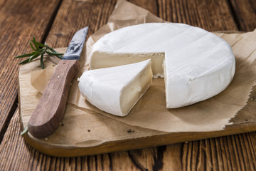 Pieces of Camembert on wooden background
