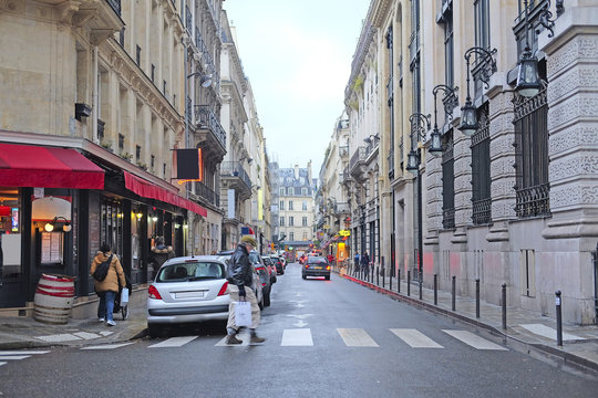 Paris, France, February 12, 2016: pedestrian cross road in a center of Paris, France