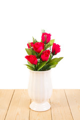 Red roses in pot on wood texture isolated on white background