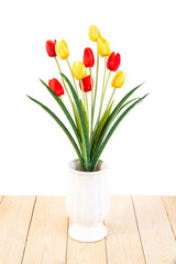 Red and Yellow tulips in pot on wood texture isolated on white b