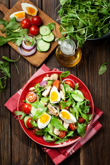 Fresh salad with chicken, tomatoes, eggs and arugula on plate