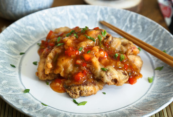 Sweet and sour pork and rice on plate with chopsticks, Chenese cuisine