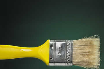 Paintbrush with yellow handle and horse hair bristle. Blank space at top