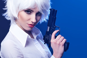 beautiful sexy girl holding gun . blue background