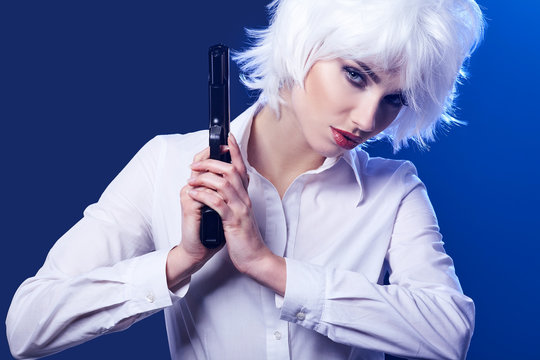 beautiful sexy girl holding gun . blue background