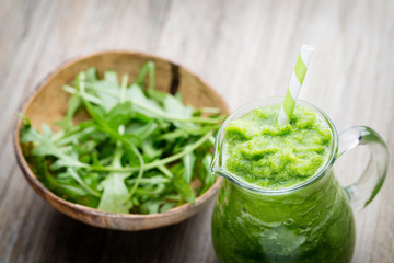 Rucola smoothie, on the grey  background.