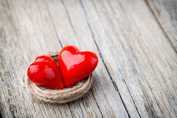 Two red heart-shaped on a wooden background.