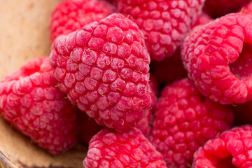 Frozen raspberries on wooden background.