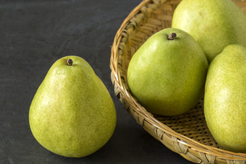 Green Anjou Pears with a bamboo tray on the slate background