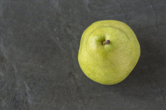 Single Green Anjou Pear on the slate background