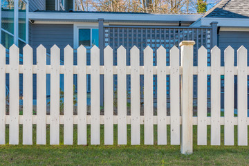 wooden fence with green lawn and houses