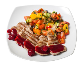Pork chops steak with cherry sauce and vegetables. In the plate on white background