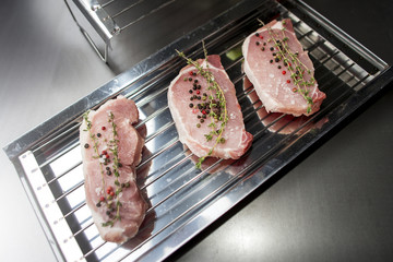 Three pieces of sliced pork with herbs and sea salt