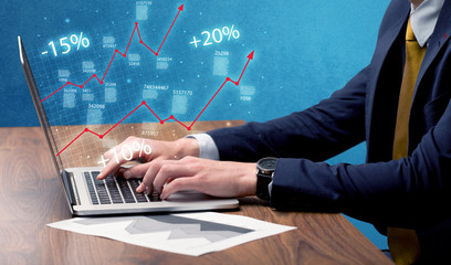 Salesman working on graph with laptop