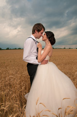 Bride and groom in a wheat field