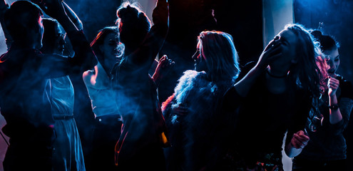 party at a nightclub, young people boys and girls dancing in a smoke - obrazy, fototapety, plakaty