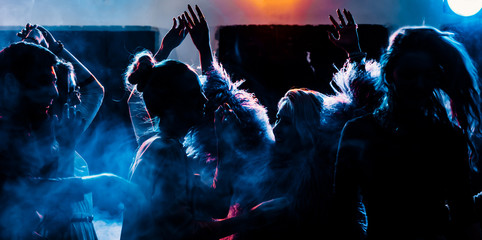Fototapeta party at a nightclub, young people boys and girls dancing in a smoke obraz