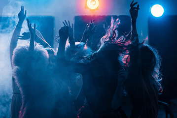 party at a nightclub, young people boys and girls dancing in a smoke - obrazy, fototapety, plakaty
